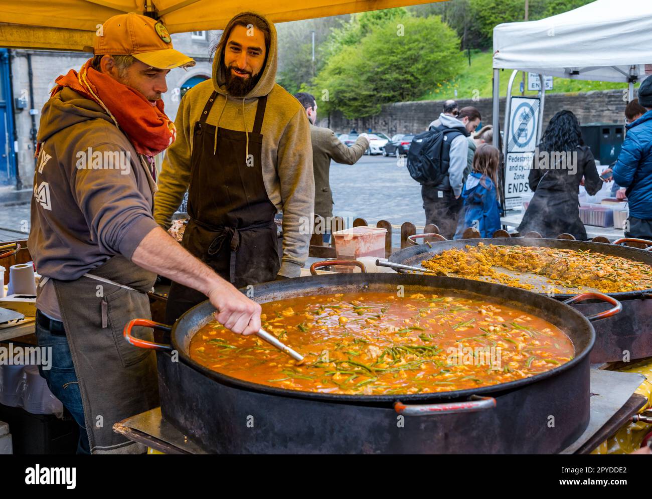Stalla di cibo che cucina pentola enorme di verdure con fagiolini verdi per paella spagnola, Grassmarket, Edimburgo, Scozia, Regno Unito Foto Stock