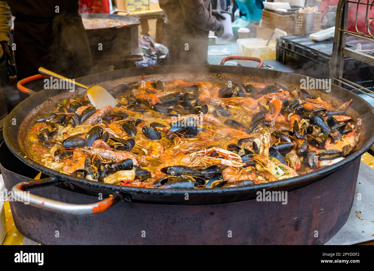 Cibo stalle cucinare enorme pentola di crostacei con cozze e langoustine per paella spagnola, Grassmarket, Edimburgo, Scozia, Regno Unito Foto Stock