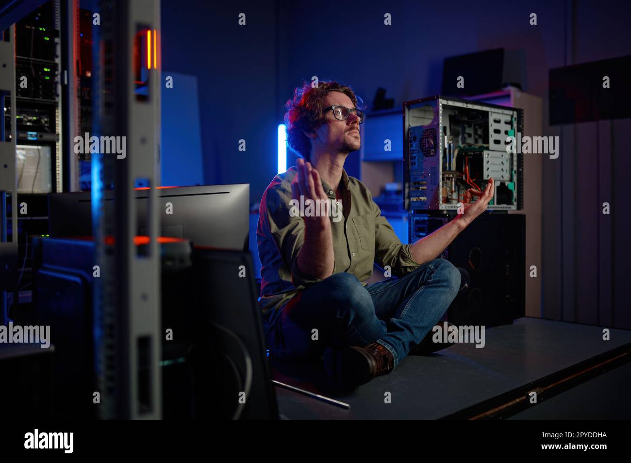 Un tecnico penoso che medita nella sala server del moderno data center Foto Stock