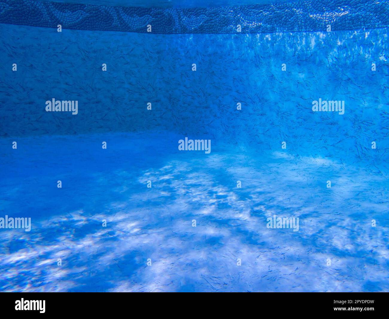 Tranquillo pavimento blu della piscina con luci e ombre subacquee Foto Stock