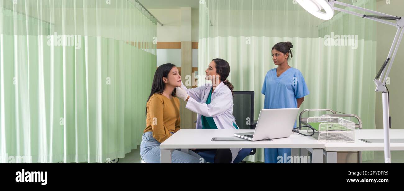 Giovane donna asiatica che si consulta sul chirurgo cosmetico e fa iniezioni di botox sul viso per le procedure di bellezza. Atmosfera presso il reparto di chirurgia estetica in clinica ospedaliera. Foto Stock