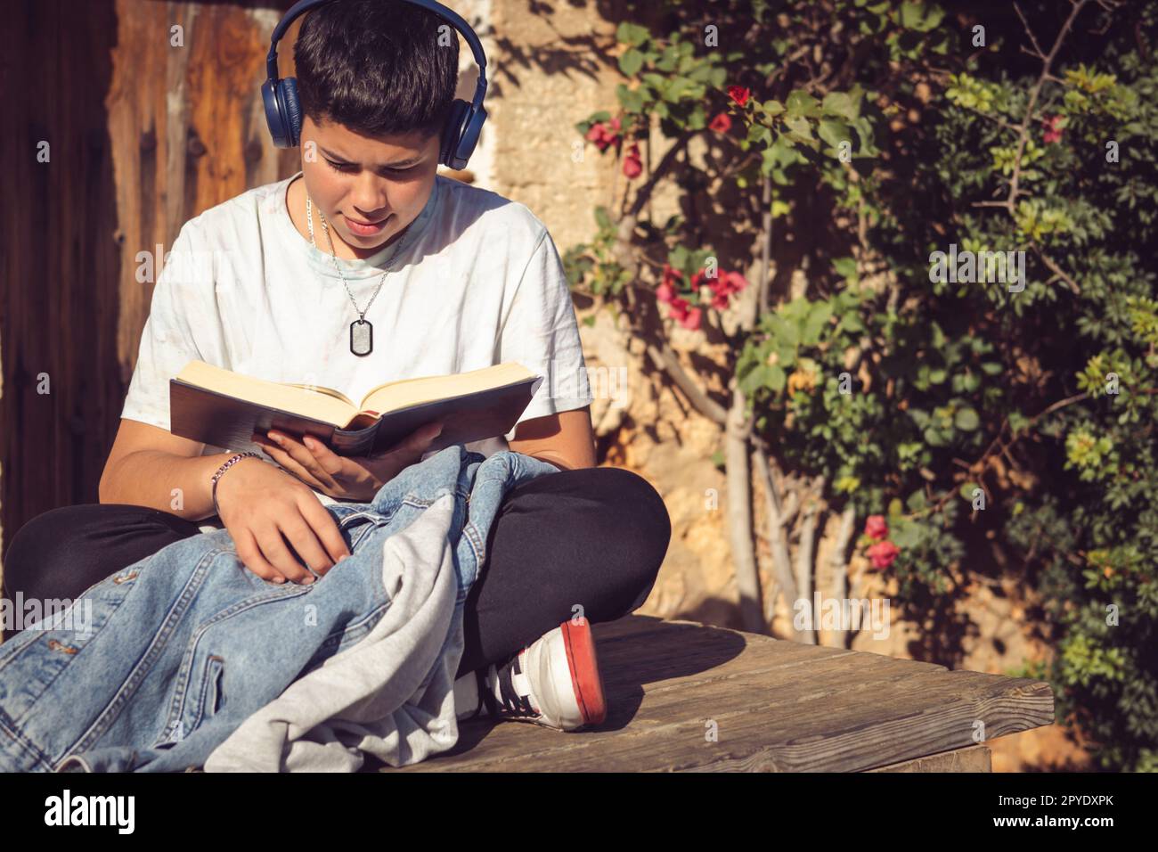 giovane uomo che legge un libro fuori in una giornata di sole Foto Stock