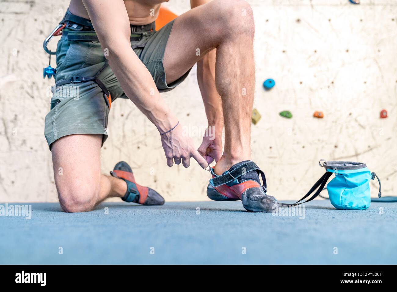 indossare scarpe da arrampicata accanto alla parete di arrampicata Foto Stock