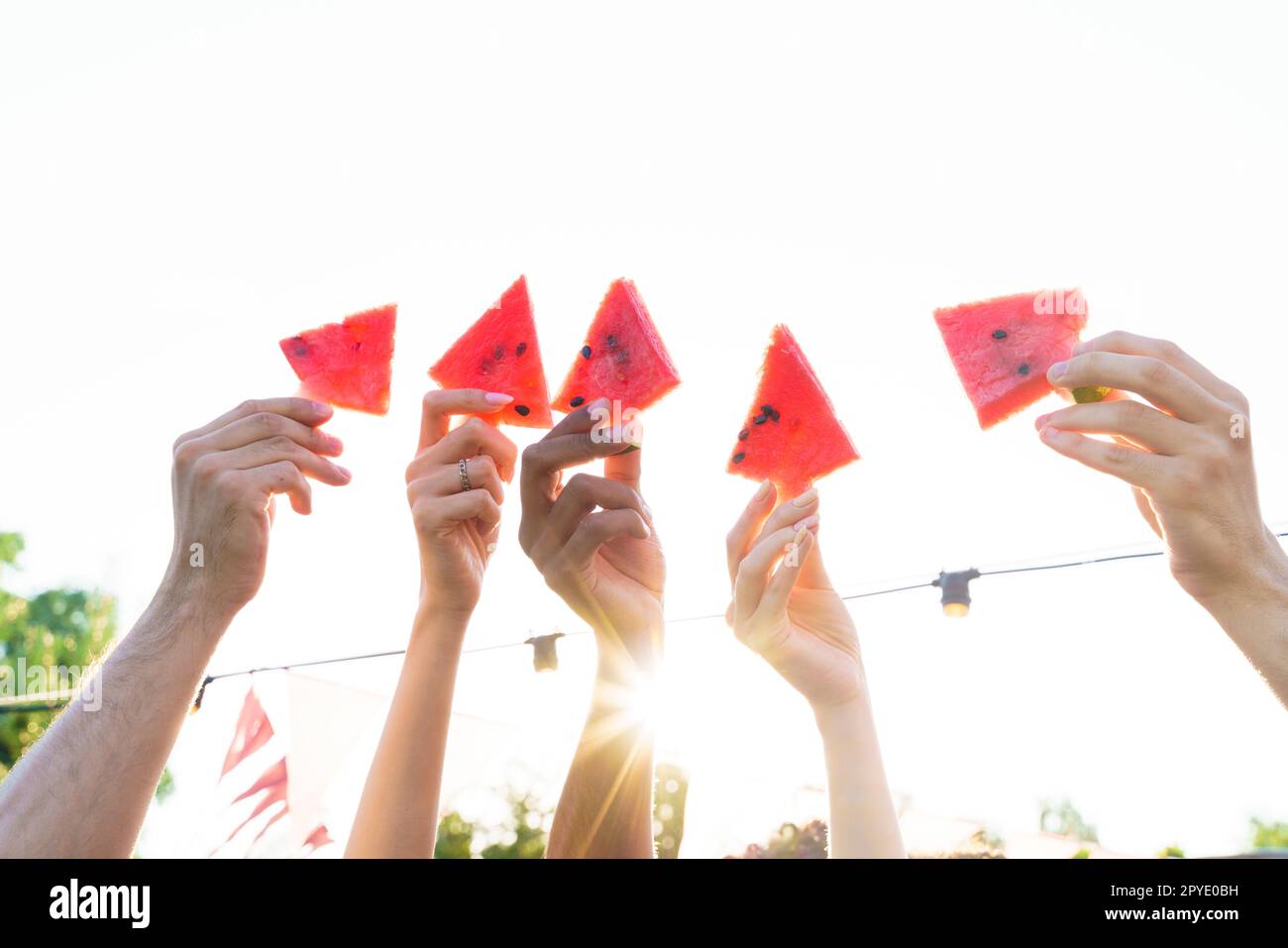 Un gruppo di amici mangia cocomeri freschi insieme Foto Stock