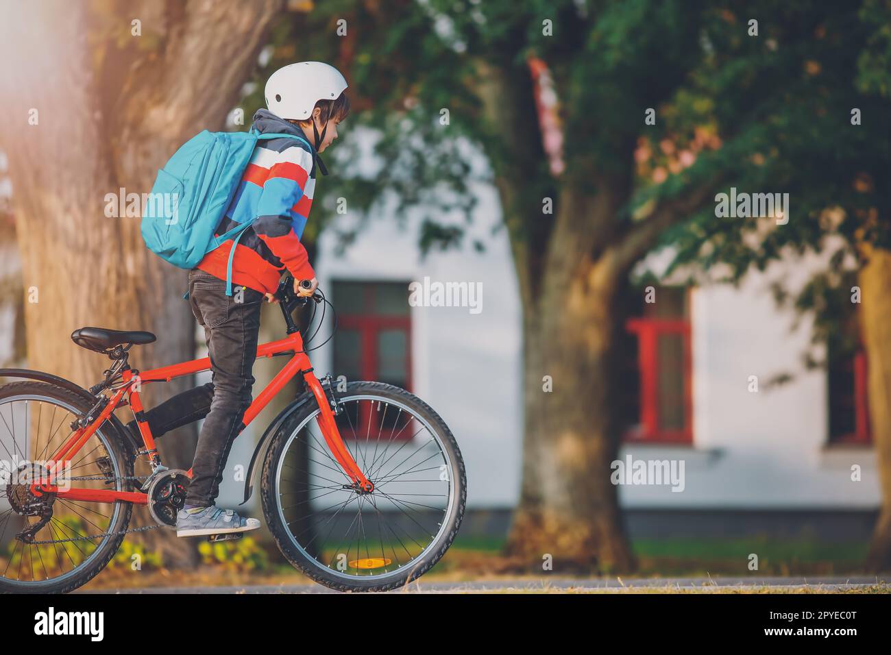 Adolescente in mattinata pedalando rapidamente in bicicletta per la lezione. Foto Stock
