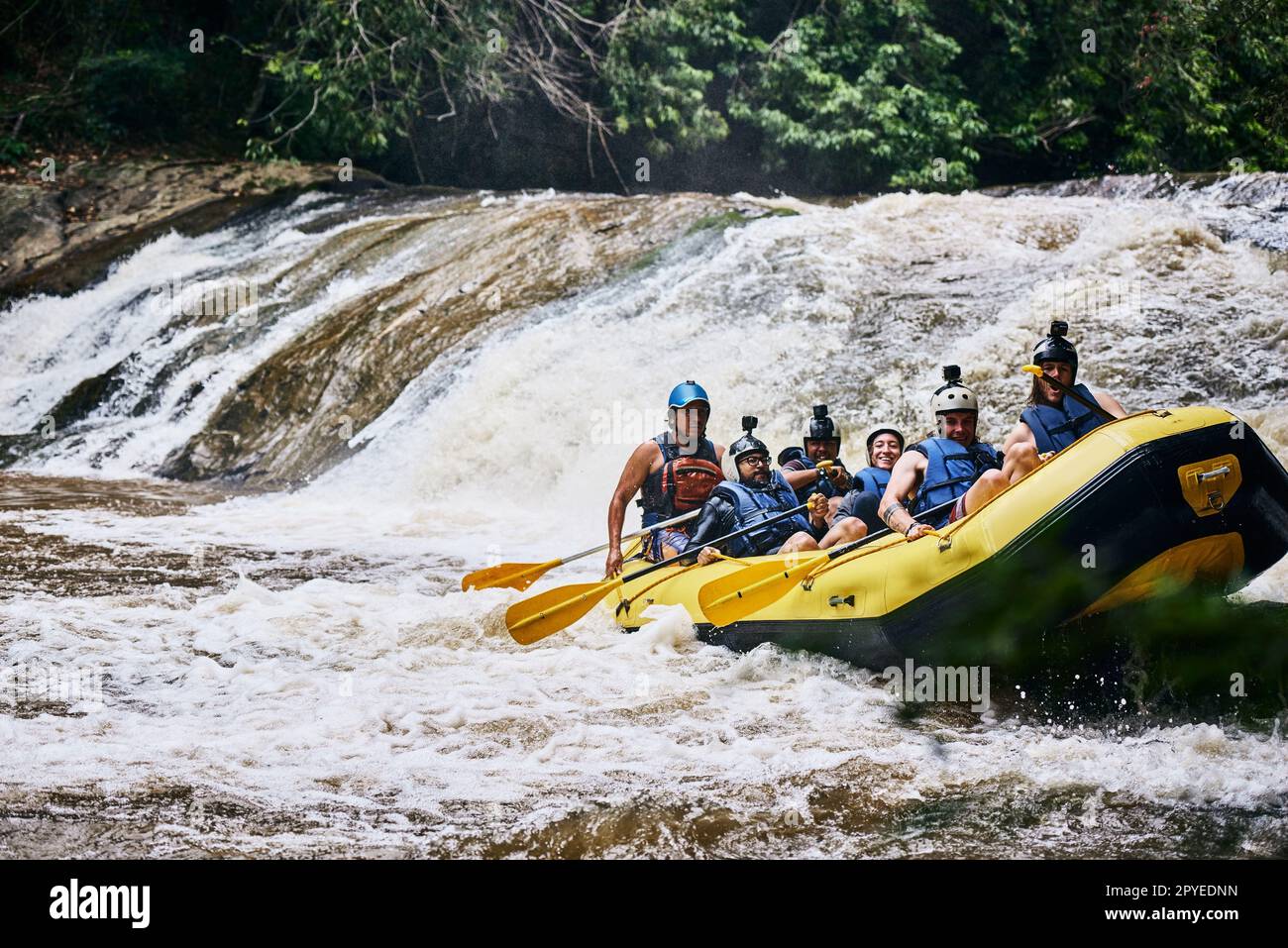 L'abbiamo fatto senza troppi problemi. un gruppo di giovani determinati su una barca di gomma occupata a pagaiare sulle forti rapide del fiume fuori durante il giorno. Foto Stock