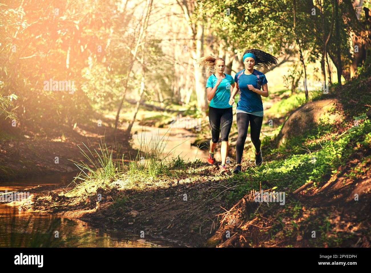 Il relativo più come un'avventura e meno come l'esercitazione. due giovani donne sportive fuori esercizio in natura. Foto Stock