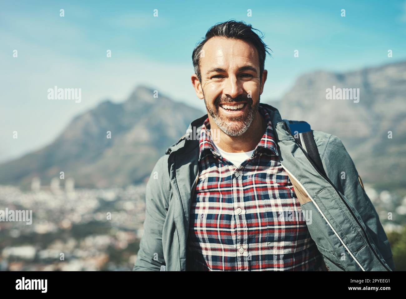 Sono finalmente arrivati giorni felici. Ritratto di un uomo di mezza età che sorride di fronte a un paesaggio montano. Foto Stock