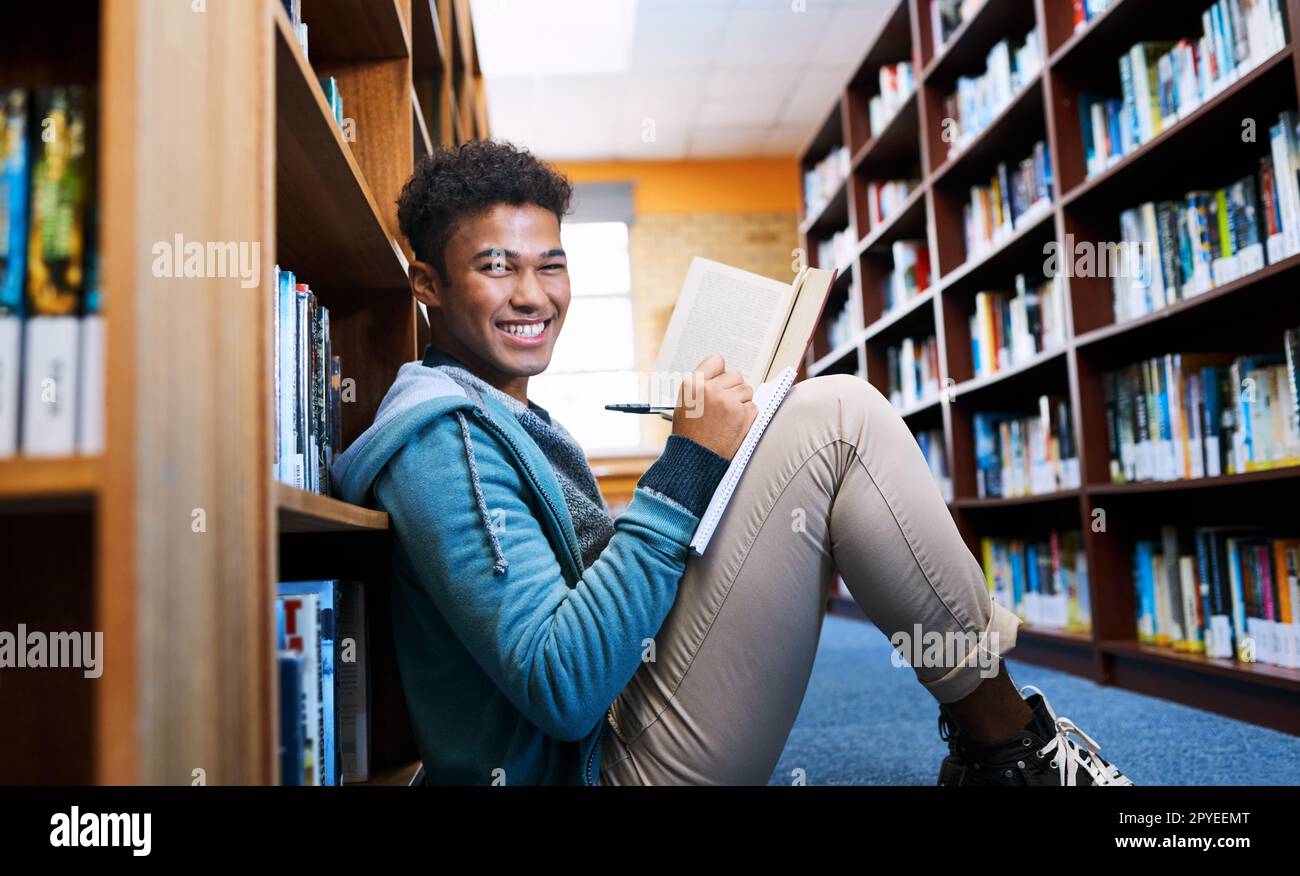 Ive ha trovato un posto tranquillo per studiare. Ritratto ritagliato di uno studente universitario che fa ricerche in biblioteca. Foto Stock