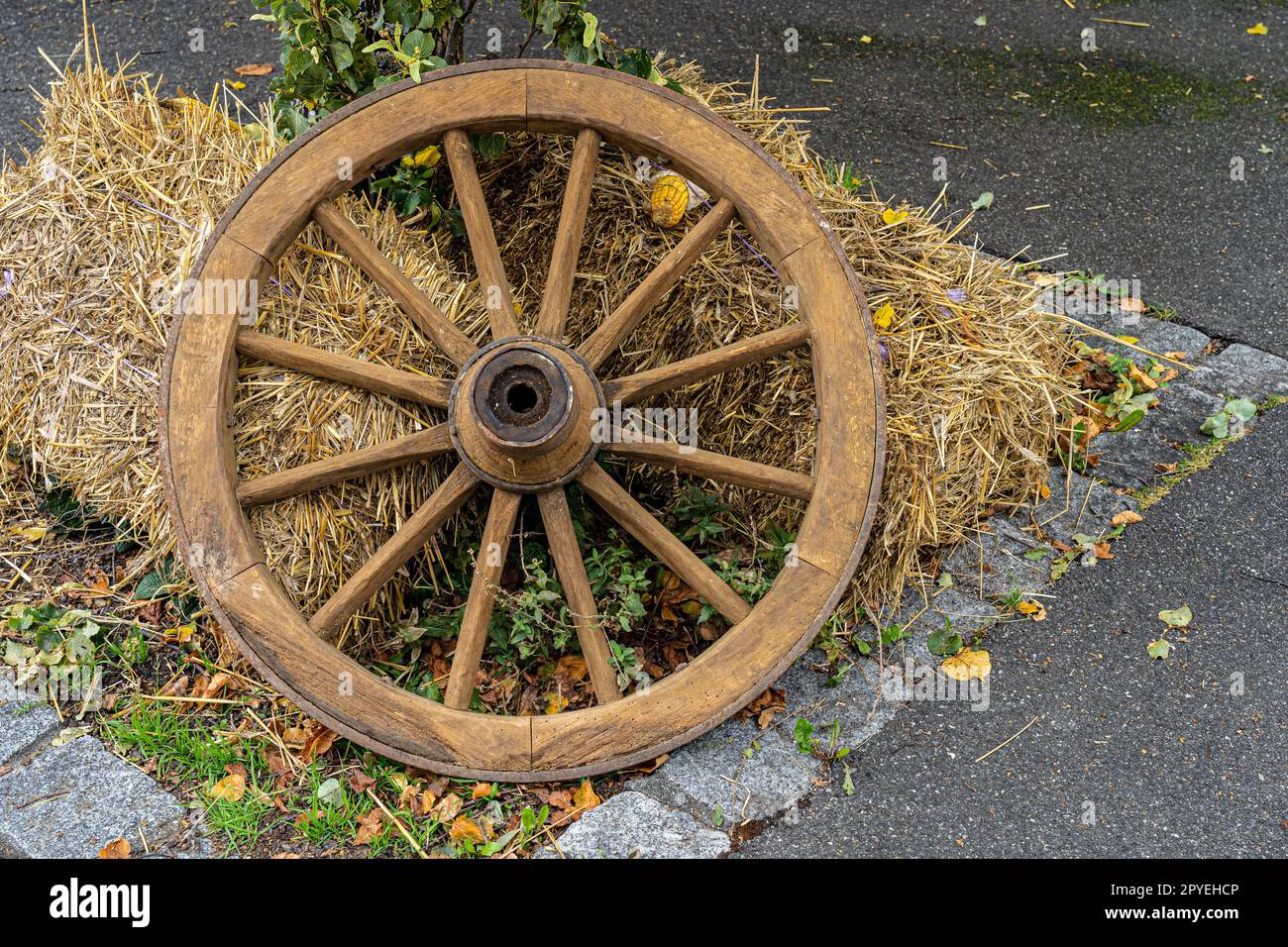 Ruota di legno e paglia come decorazione sul terreno Foto Stock