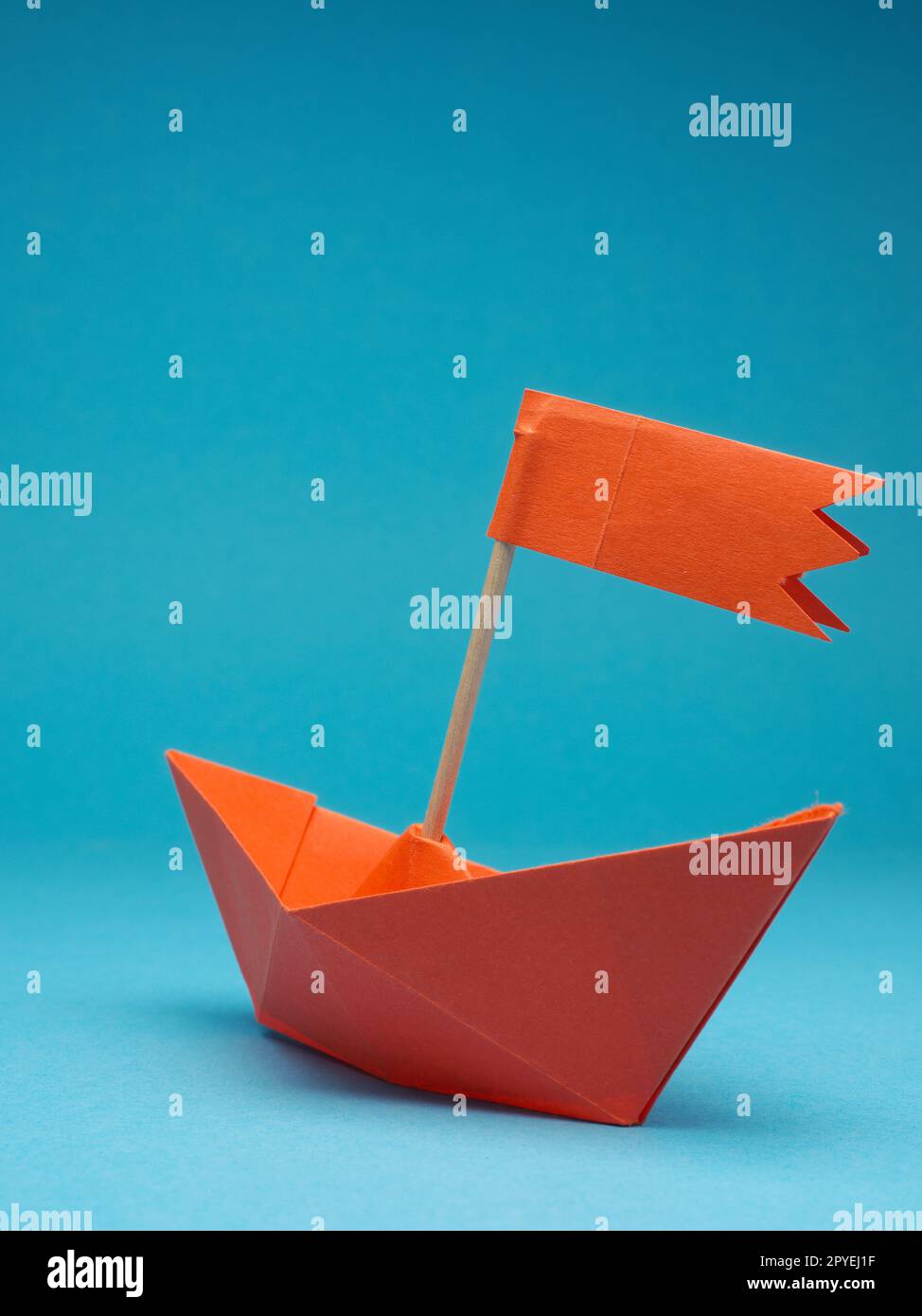 Nuove idee o concetto di trasformazione con un'imbarcazione di carta su sfondo blu Foto Stock