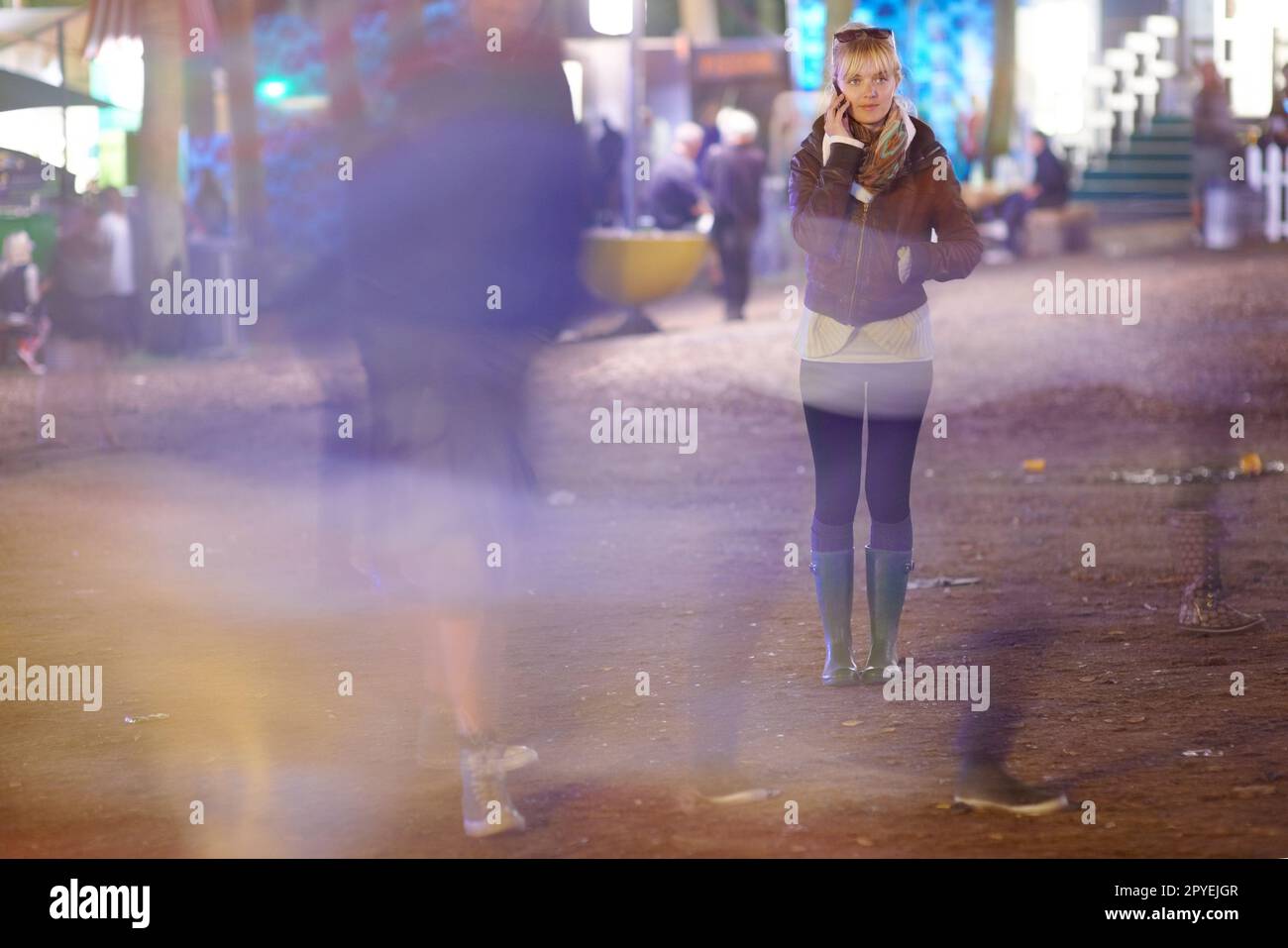 Ehi, puoi venire a prendermi. Giovane donna in piedi fuori di notte parlando sul suo cellulare - copyspace. Foto Stock