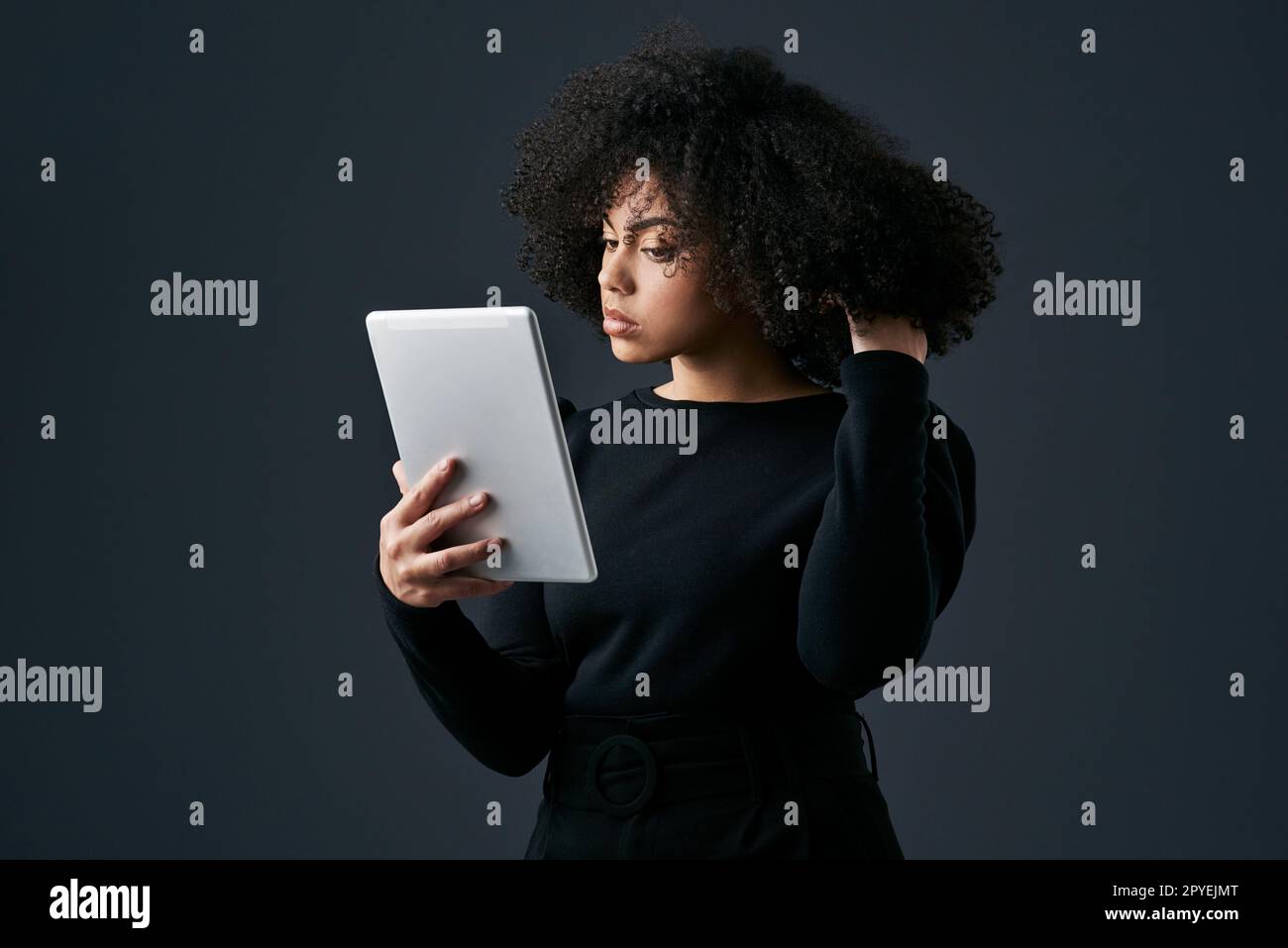 Non perdete mai un buon affare. una giovane donna d'affari che utilizza un tablet digitale su uno sfondo studio. Foto Stock