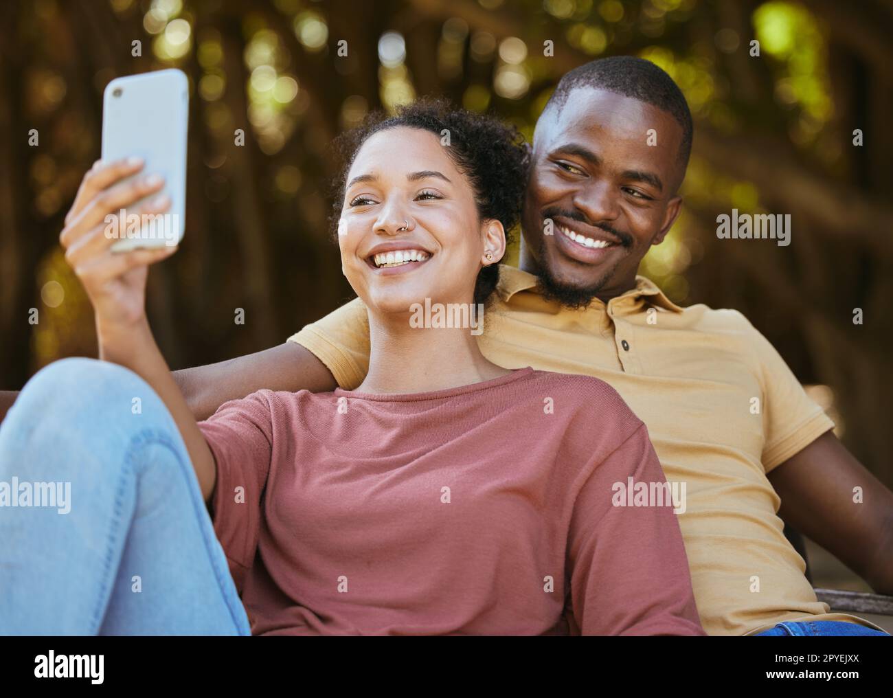 Coppia nera, telefono e selfie con sorriso al parco naturale all'aperto per viaggi, felicità e aggiornamento del contenuto delle foto del profilo dei social media. Uomo e donna felici con connessione di rete 5g in vacanza Foto Stock