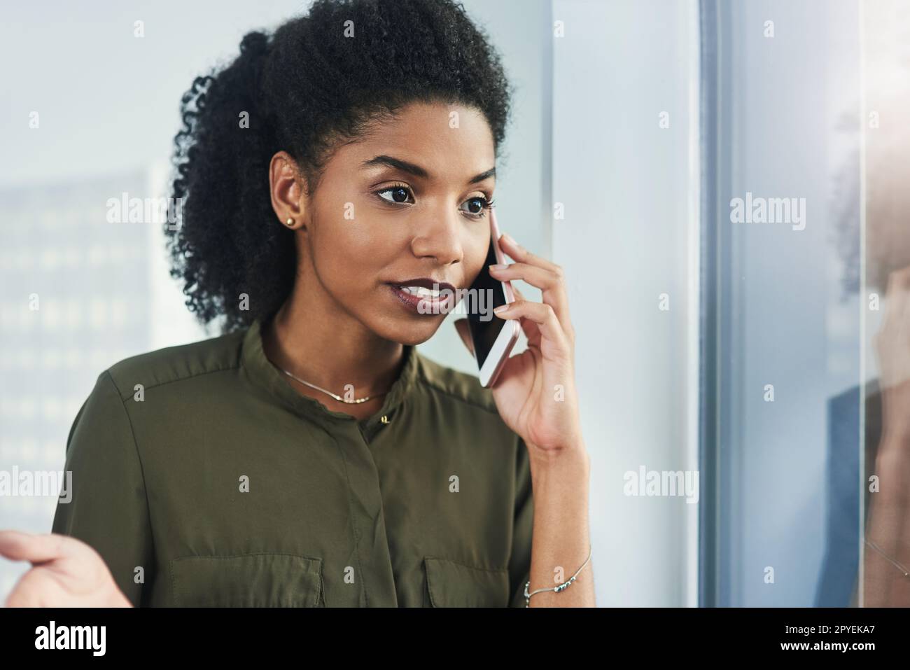 Il carattere parla sempre più forte delle parole. Primo piano scatto di una giovane donna d'affari che effettua una telefonata nel suo ufficio. Foto Stock