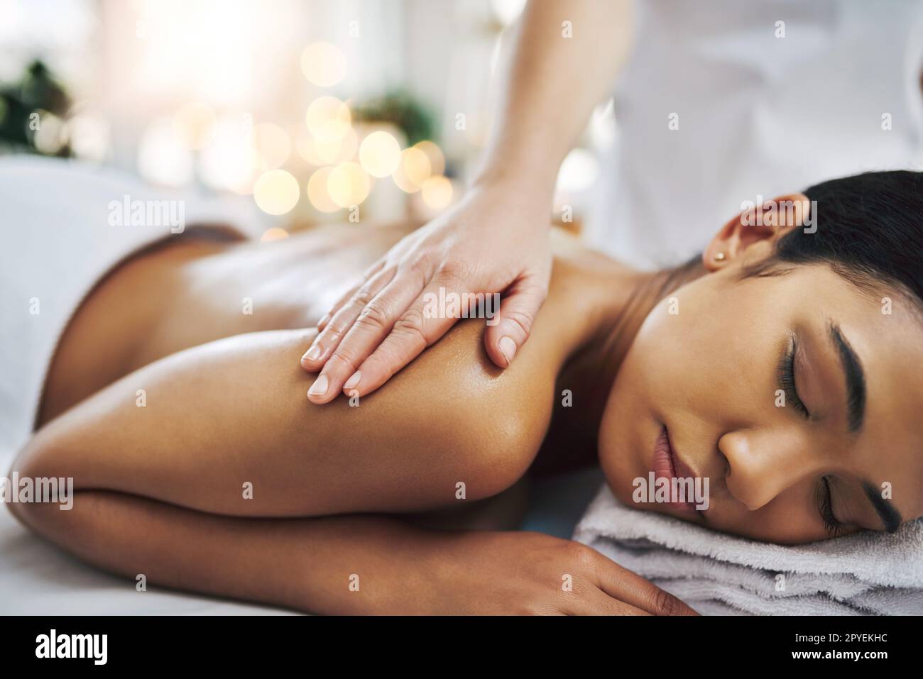 Calmare il corpo e l'anima della mente. una giovane donna rilassata e allegra che ottiene un massaggio all'interno di una spa. Foto Stock