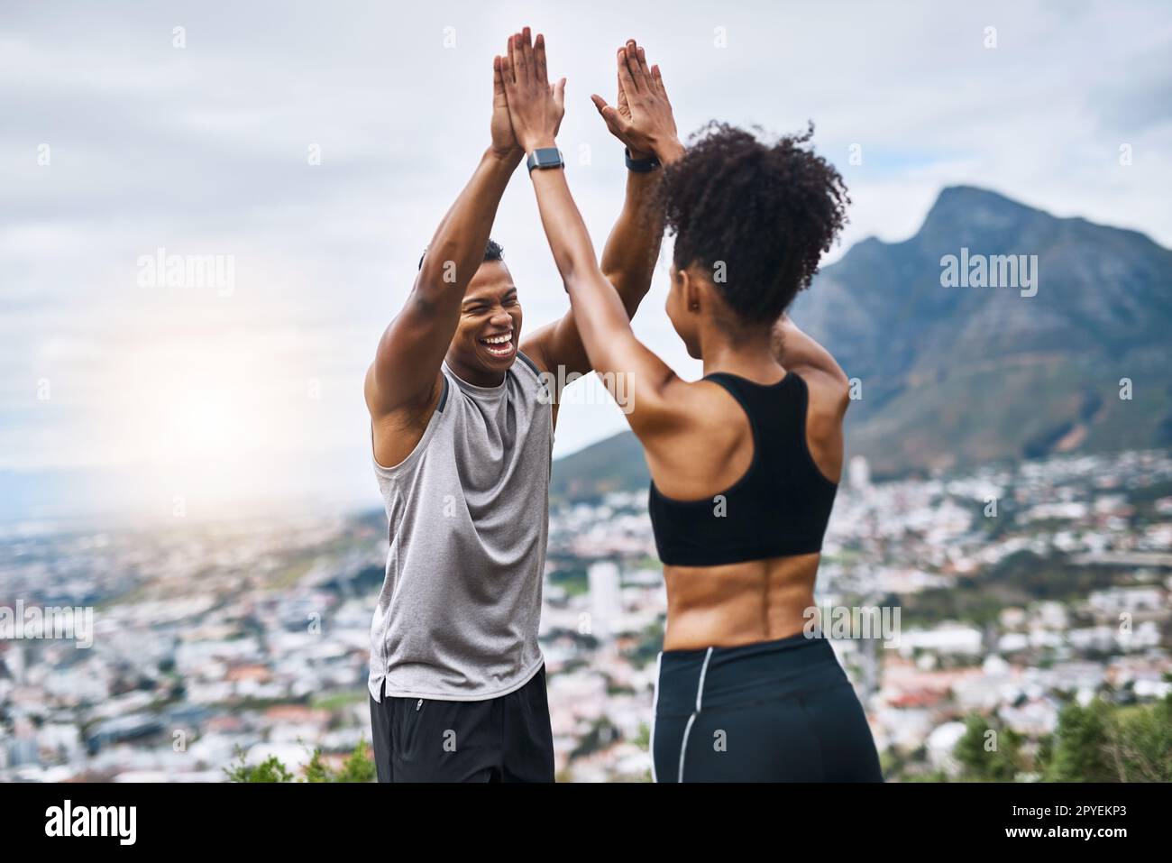 Abbiamo fatto un nuovo record. una giovane coppia sportiva che si five l'un l'altro mentre si esercita all'aperto. Foto Stock