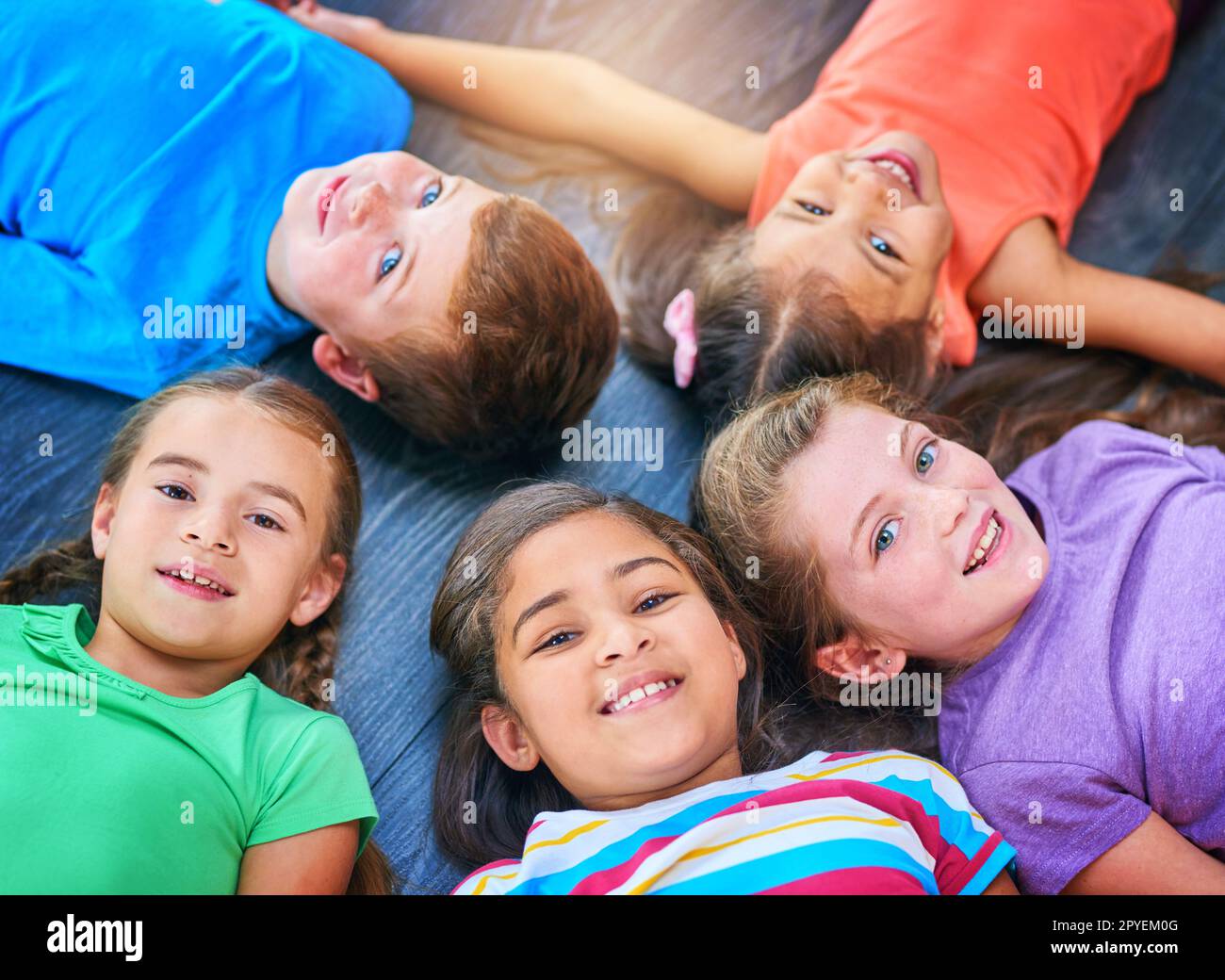 Gli amici sono le cose più belle che si possono avere. un gruppo diversificato di bambini che si trovano insieme sul pavimento. Foto Stock