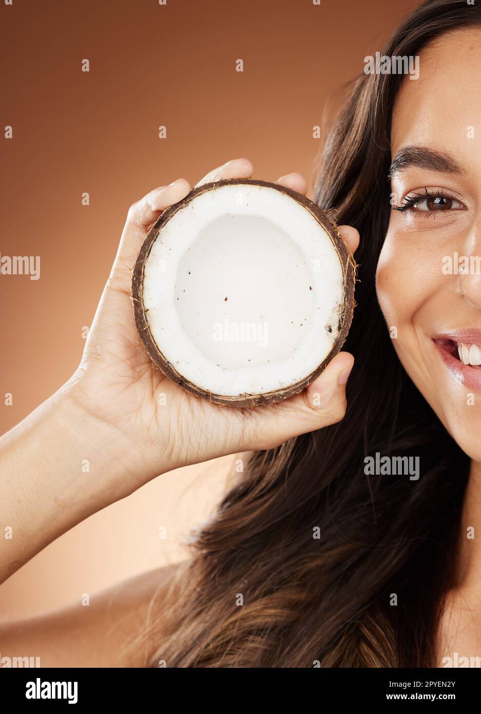 Cocco donna per la cura della pelle, sorriso e studio con cura di sé felice, nutrizione della frutta o salute cosmetica. Modello, benessere della pelle o bellezza per olio di cocco, idratante o cosmetici sfondo per un'illuminazione naturale Foto Stock