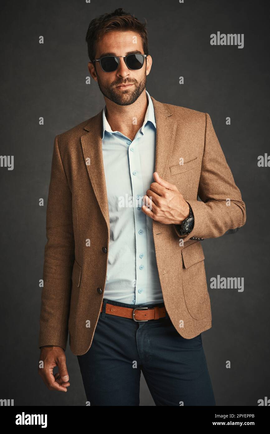 In posa potente. Studio di un bel giovane uomo che si posa su uno sfondo grigio. Foto Stock