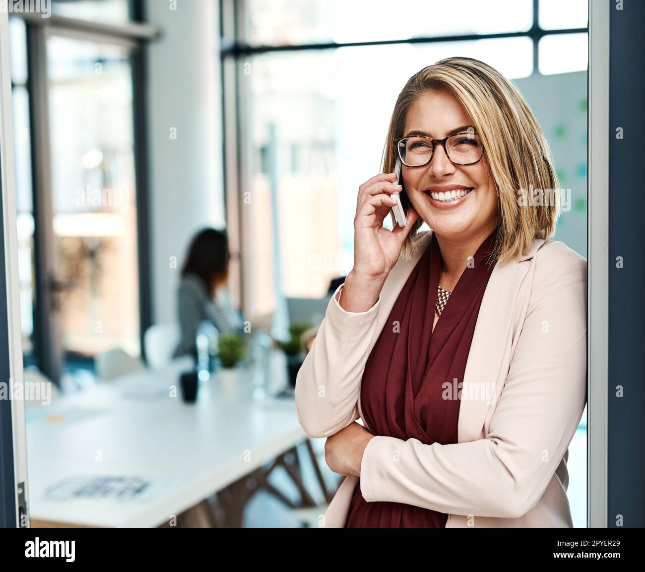 Fornire un servizio eccezionale a tutti i suoi clienti. una donna d'affari che parla su un cellulare in un ufficio. Foto Stock