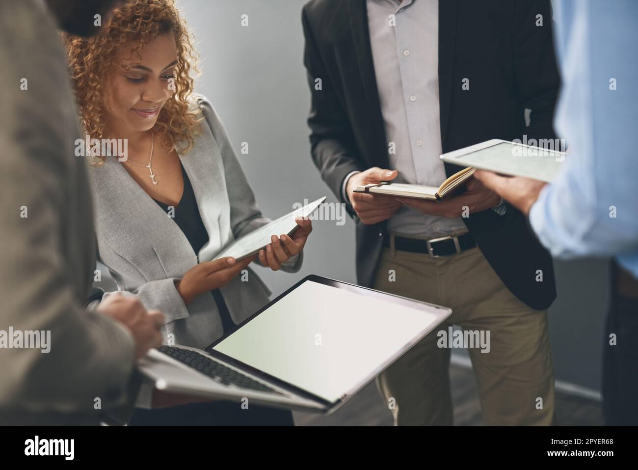 Condividere idee per il loro ultimo progetto. un gruppo di uomini d'affari che utilizzano dispositivi digitali durante il brainstorming in un ufficio. Foto Stock