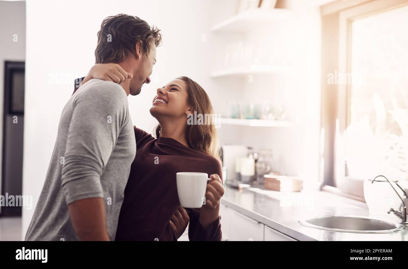 Il tuo amore è la mia luce. una giovane coppia affettuosa che ha una pausa caffè a casa. Foto Stock
