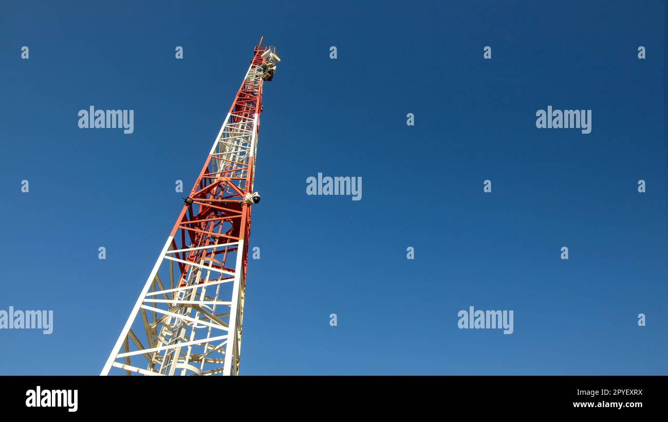 Cerca fino a piccoli di colore rosso e bianco telecommunications tower, piatti di comunicazione sulla parte superiore. Tecnologia astratta sfondo, spazio per il testo sulla destra. Foto Stock