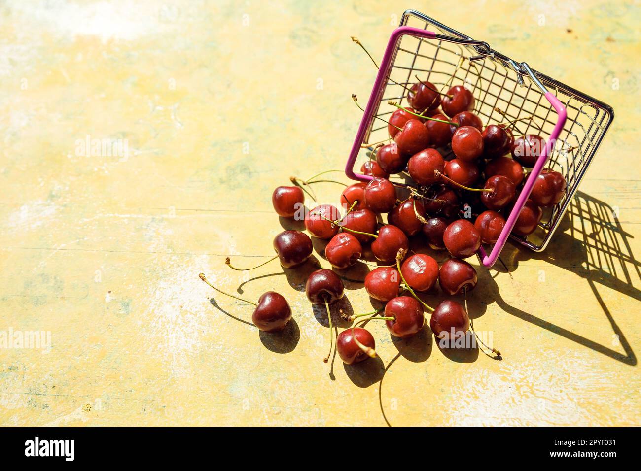 Rosso fresco frutta e bacche - di ciliegie, di pesche e di fragole - in carrello per supermercati vassoio su sfondo nero. Spazio di copia Foto Stock