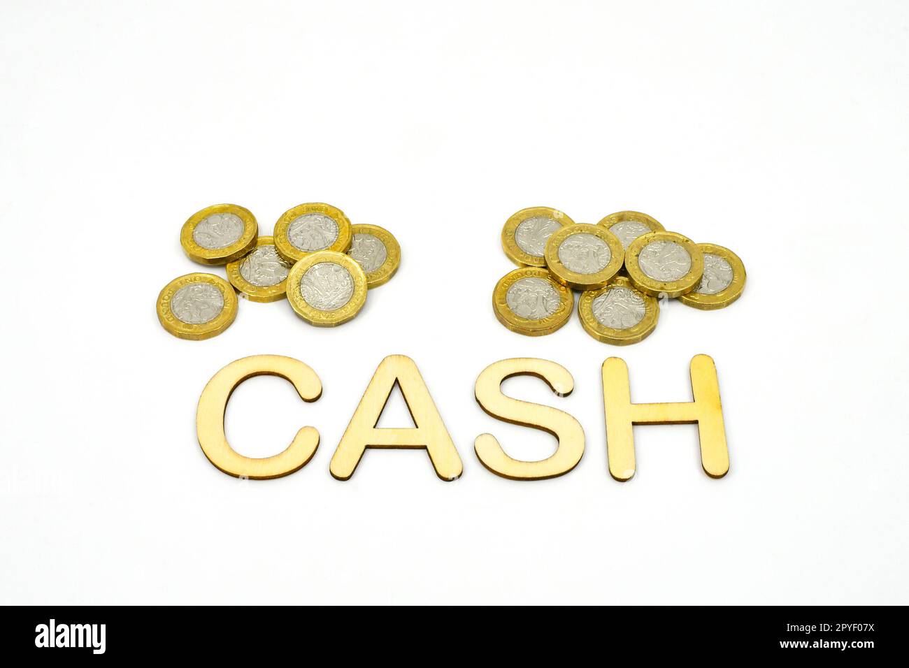 Word Cash in lettere isolate su fondo bianco con monete britanniche da una libbra. Spazio di copia. Concetto di spesa. Foto Stock