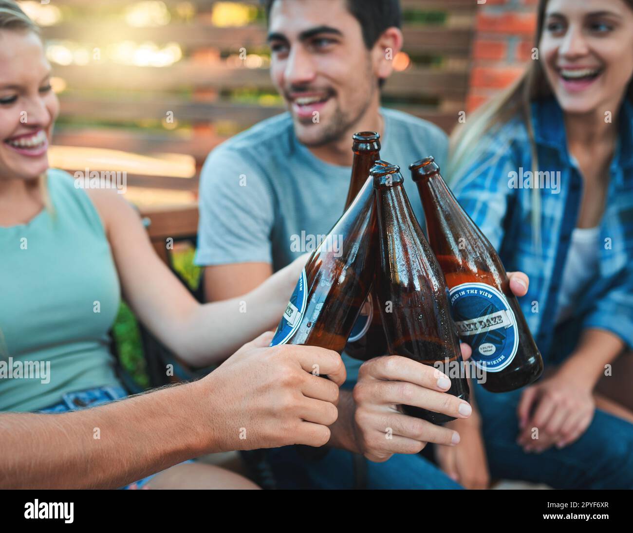 Brinda ai migliori tempi di sempre. un gruppo di amici che si appendono insieme e brinda con le birre. Foto Stock