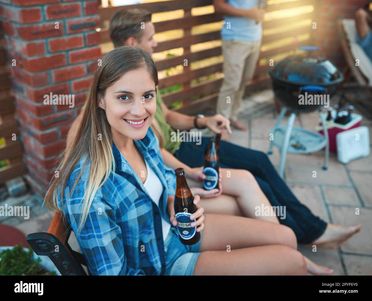 Che fine settimana di estate sono stati fatti per. una giovane donna felice che gustava una birra al barbecue con i suoi amici. Foto Stock