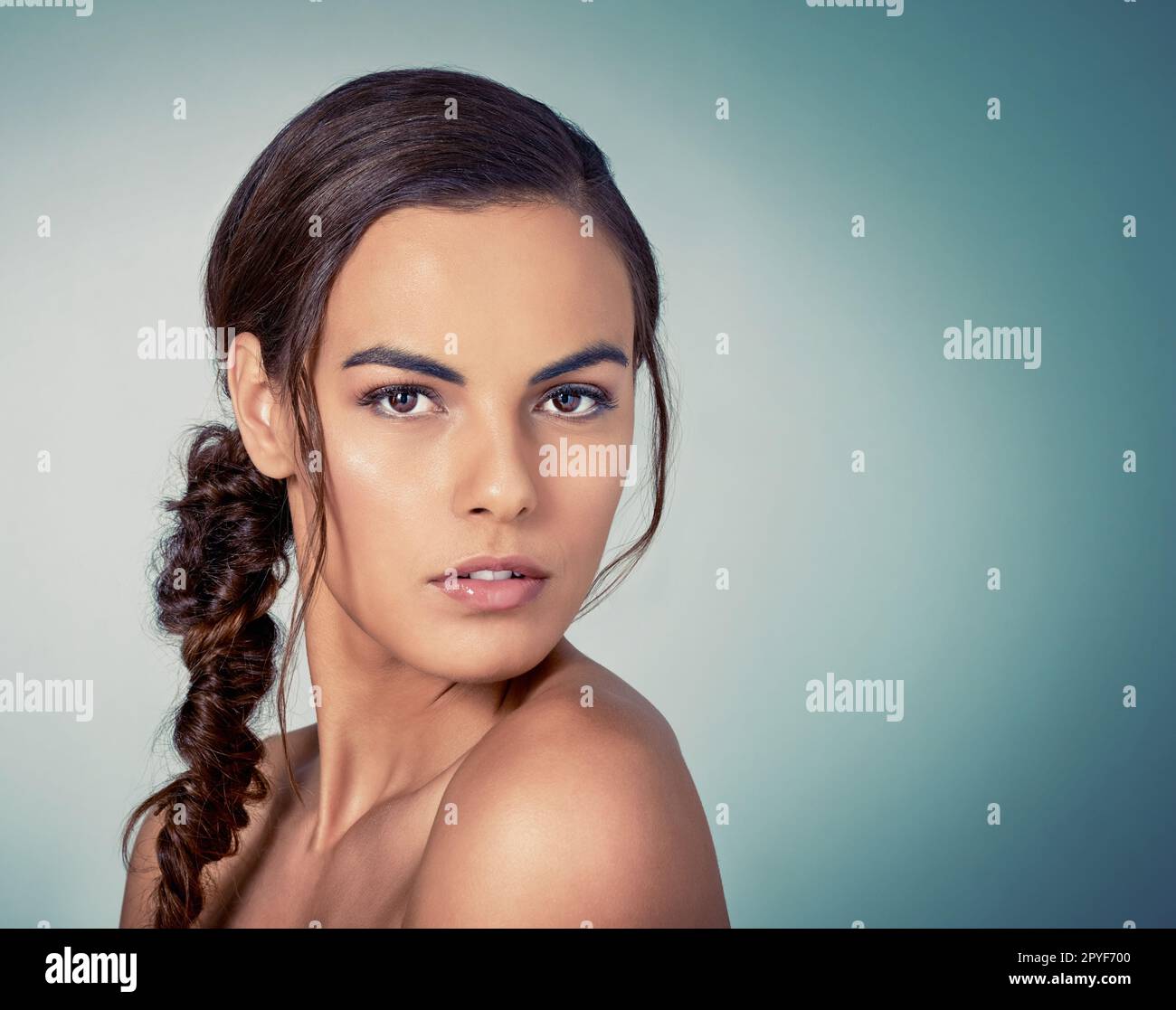 Capelli grandi perché ottenete soltanto una prima impressione. Studio di una bella giovane donna che posa su uno sfondo verde. Foto Stock