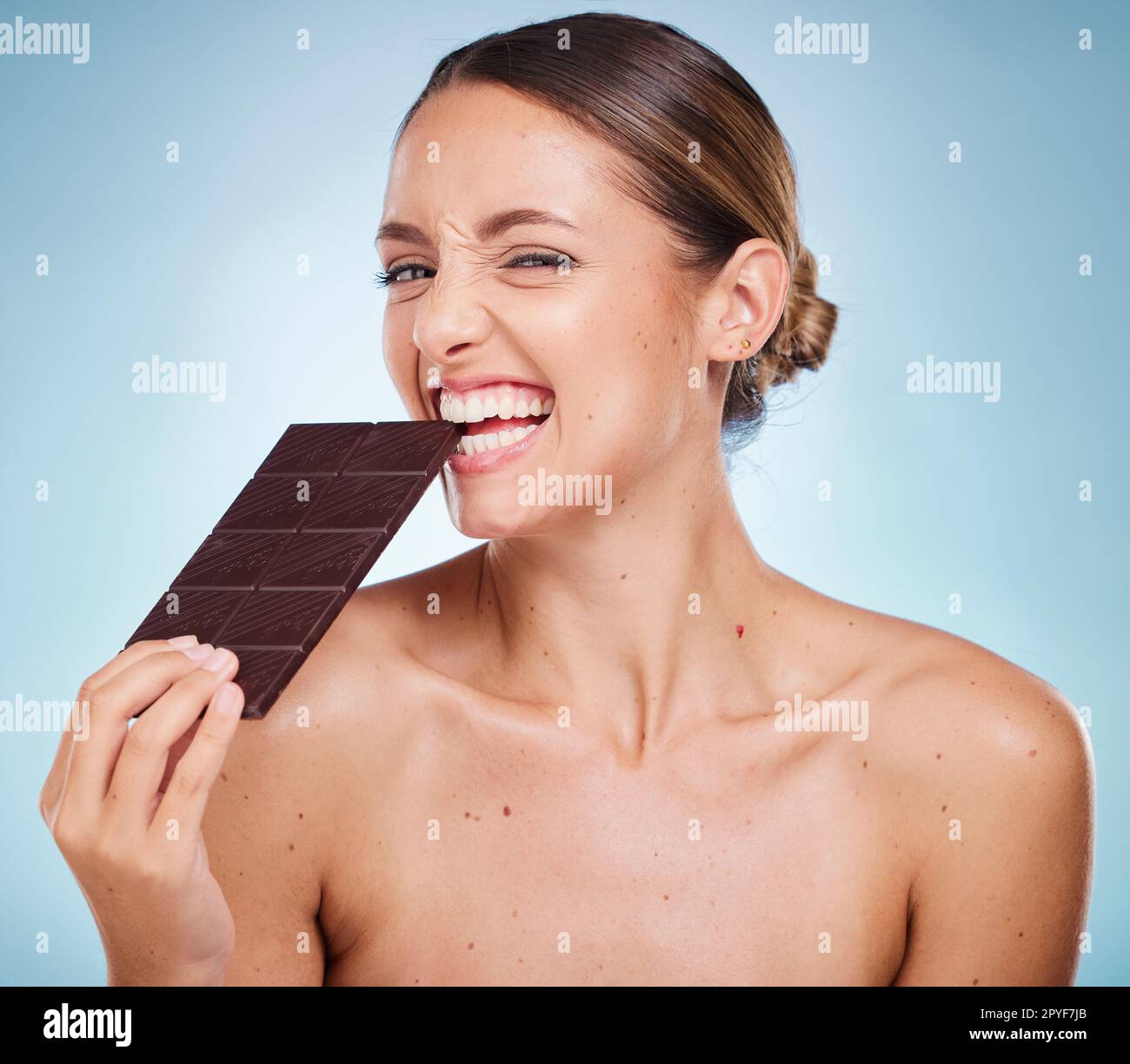 Cioccolato, dieta e bellezza con donna e cura della pelle con caramelle salutari, lusso e benessere con cibo e ritratto. Felice con calorie, cosmetici e dessert al cacao con pelle sullo sfondo dello studio Foto Stock