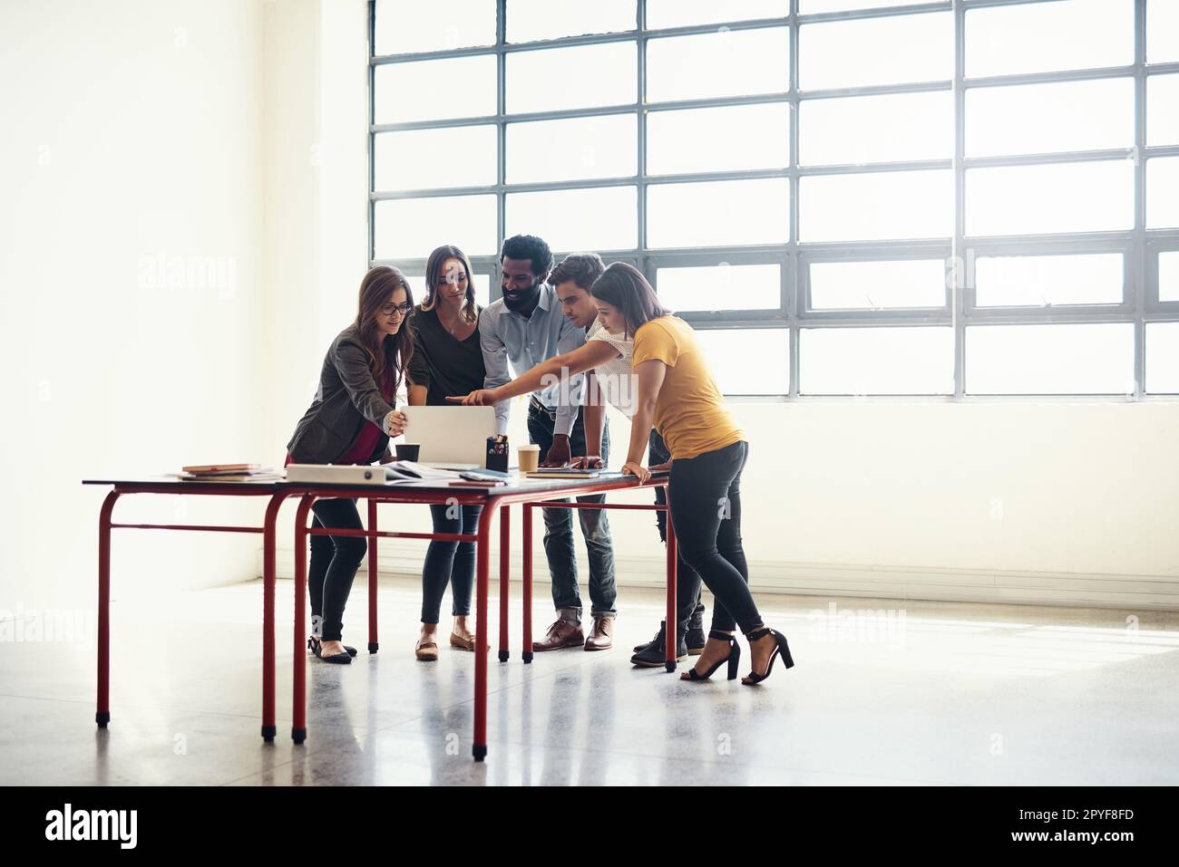 Alzati e crea, lascia fare questo. dipendenti creativi che si riuniscono in un ufficio moderno. Foto Stock