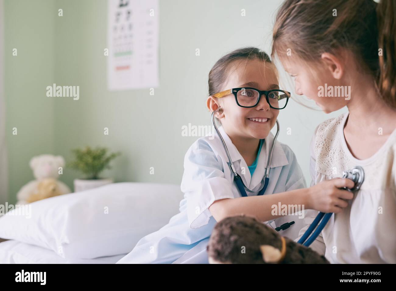 Non potete controllare completamente uno sviluppo dei bambini. una bambina che finge di essere un medico mentre esamina la sua amica. Foto Stock