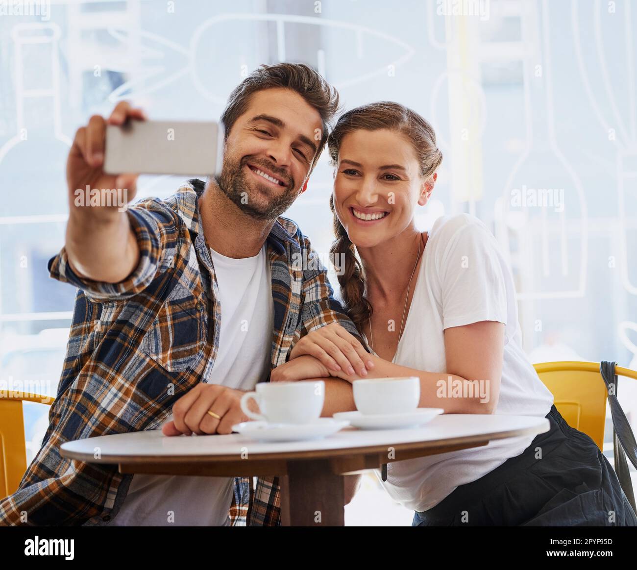 Theyre non selfie timido. una giovane coppia felice in posa per un selfie insieme in una caffetteria. Foto Stock