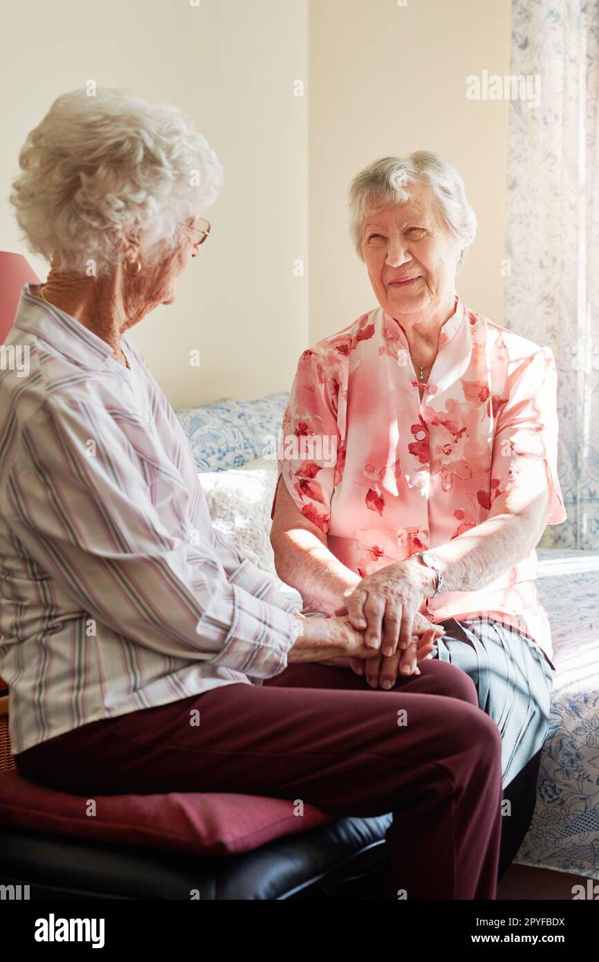 Quei catch up regolari significano così tanto. due donne anziane felici che chiacchierano in una casa di riposo. Foto Stock