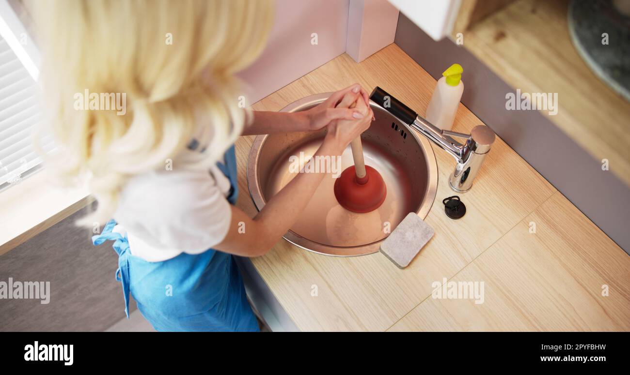 Pulizia dell'ostruzione dello scarico nel lavandino della cucina Foto Stock