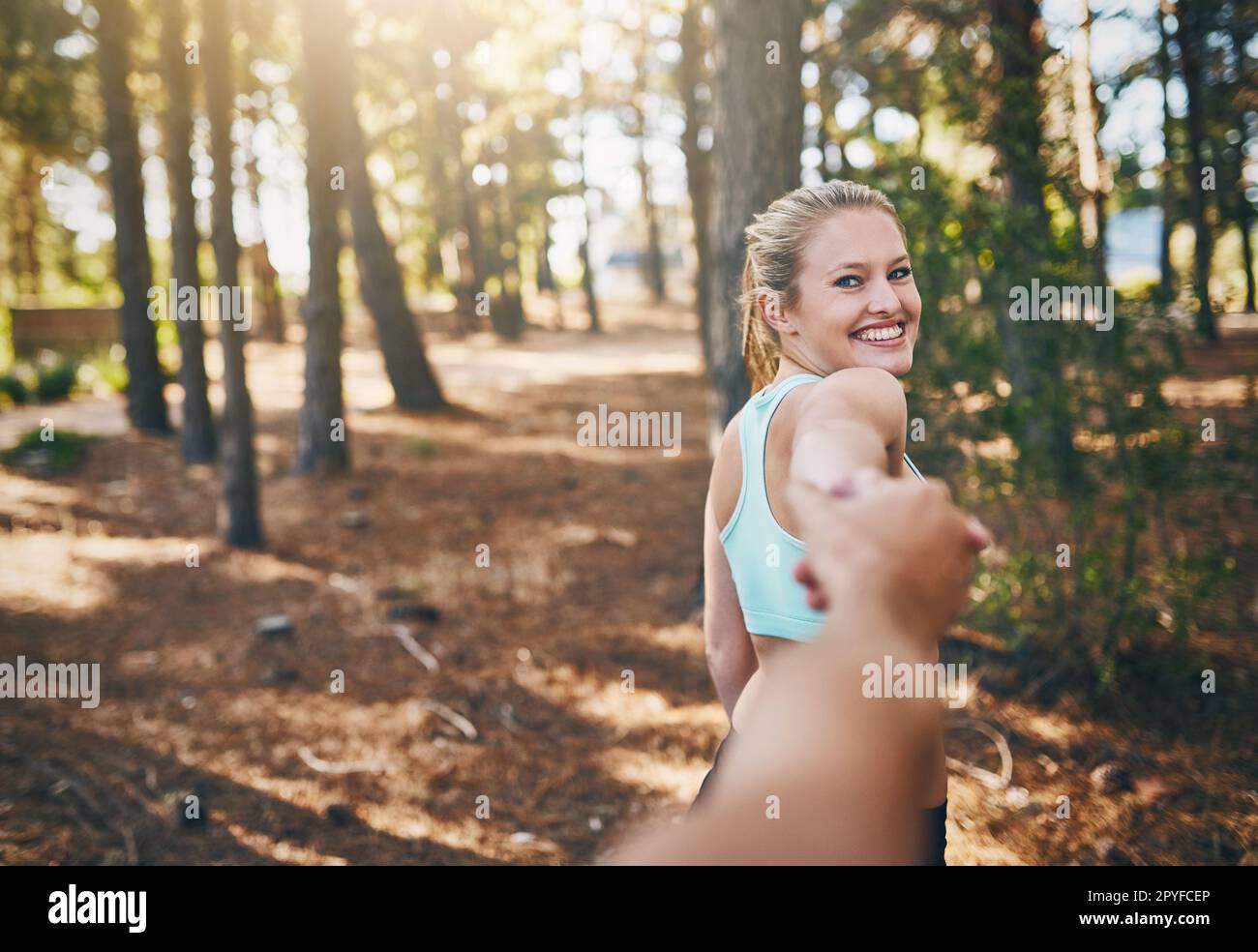 Seguimi in forma. Prospettiva personale ripresa di una giovane donna che tira il suo ragazzo nella foresta. Foto Stock