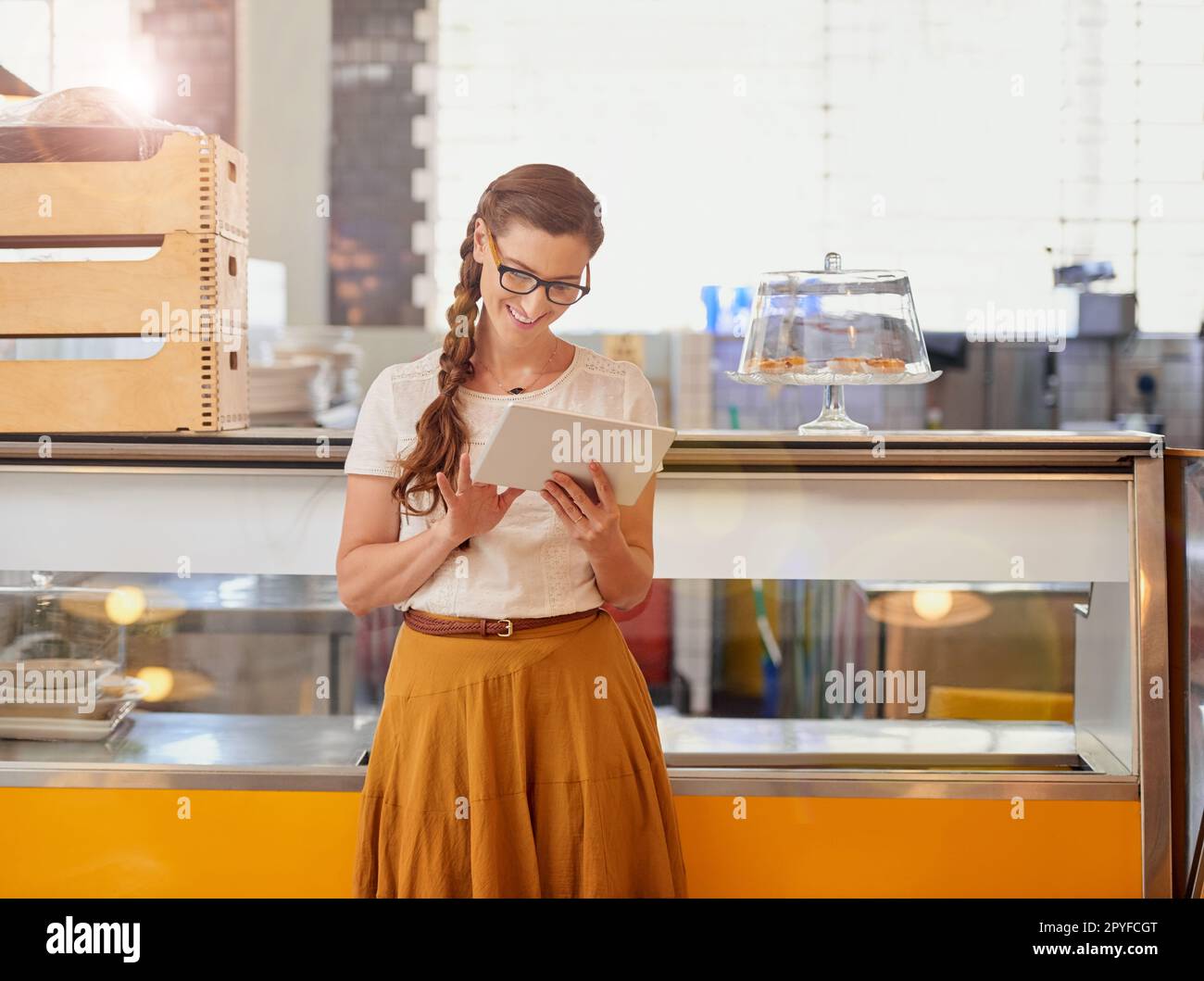 Non perdere tempo, ottenere il vostro business online. felice titolare di un'azienda giovane che utilizza un tablet mentre si trova nella sua caffetteria. Foto Stock