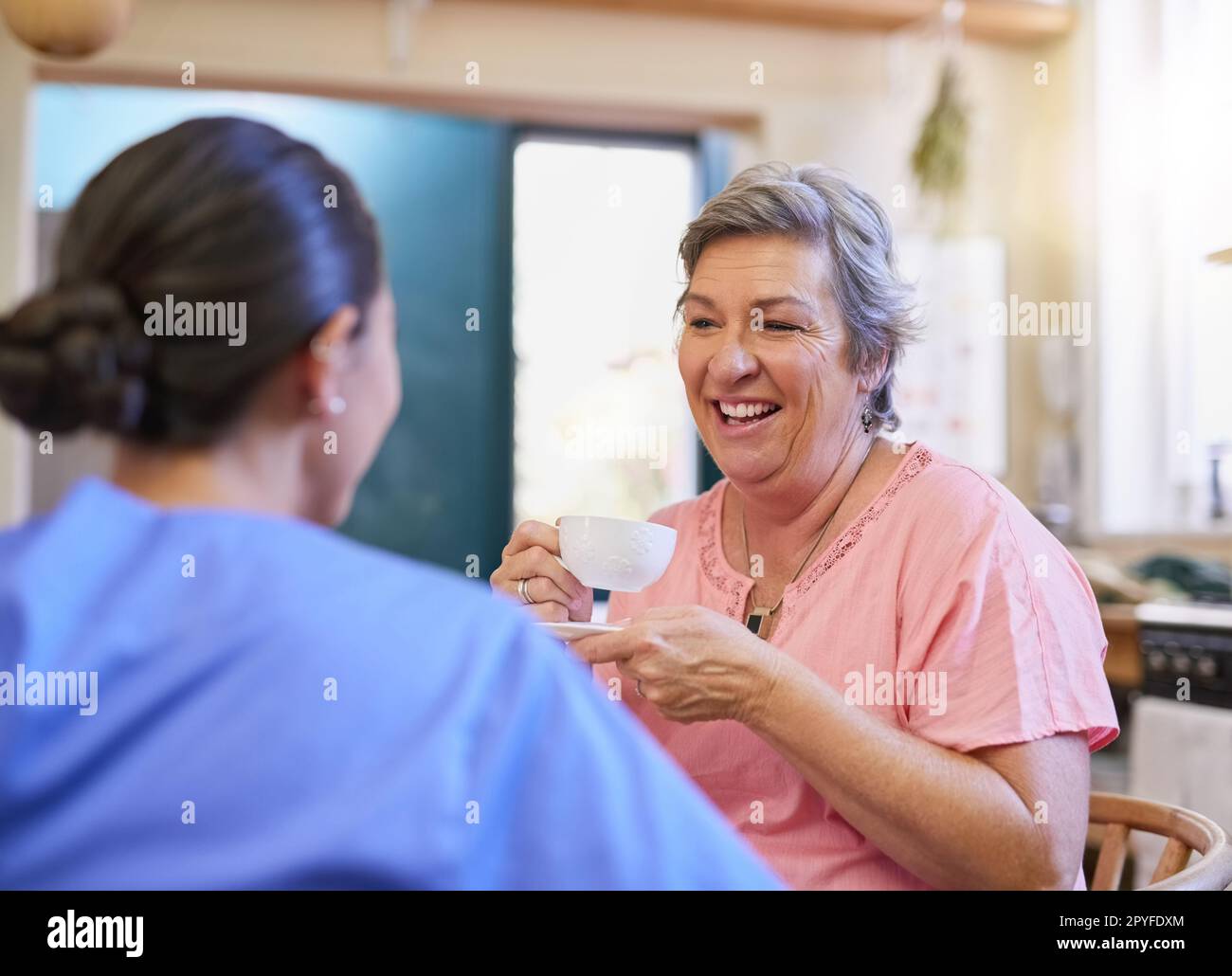 Le ceneri hanno avuto abbondanza delle storia da ripartire. un operatore sanitario che chiacchiera con un paziente anziano in una casa di cura. Foto Stock