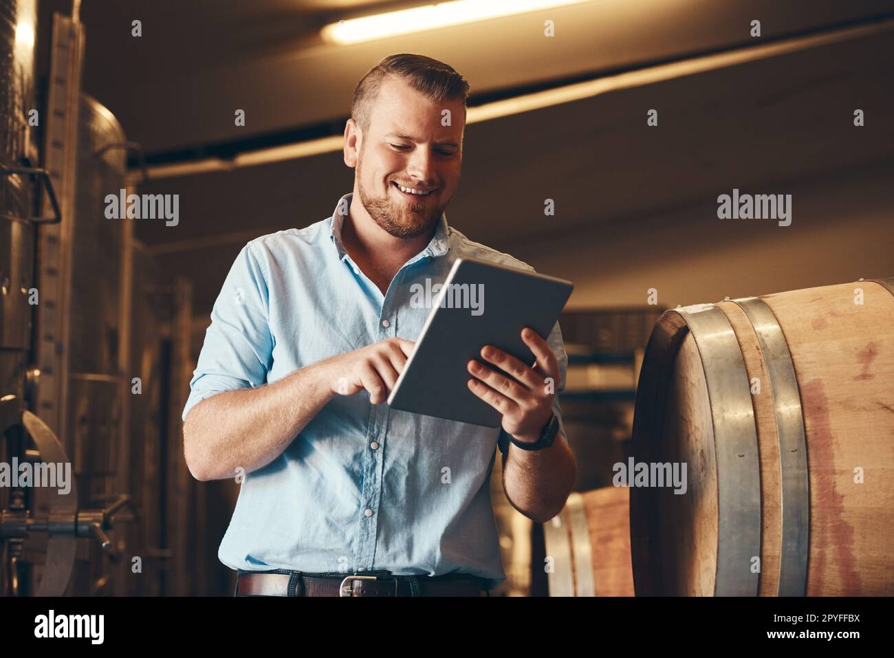 Se non avete una soluzione, trovane una online. un bel giovane sommelier maschile che usa il suo tablet digitale al lavoro. Foto Stock