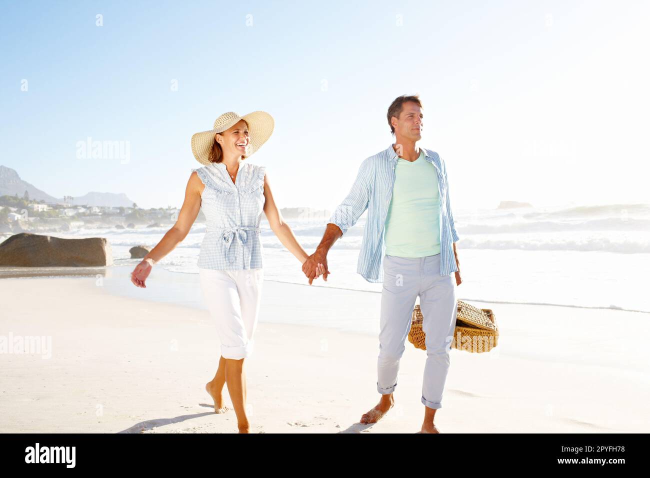 Mano in mano lungo la spiaggia. Una coppia beata che si gode una bella giornata in spiaggia insieme. Foto Stock