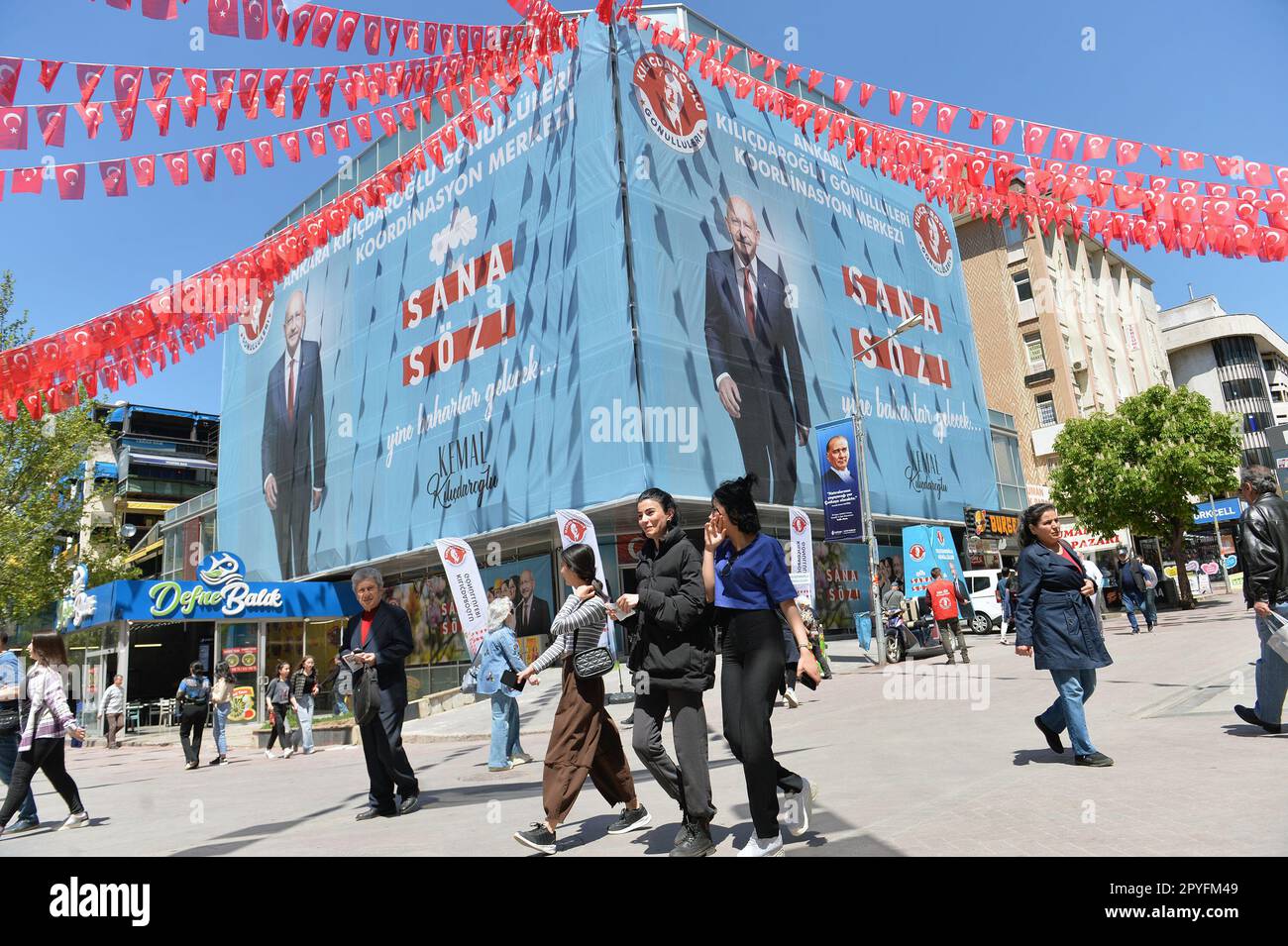 Ankara, T¨¹rkiye. 3rd maggio, 2023. La gente passa i manifesti delle campagne elettorali ad Ankara, T¨¹rkiye, il 3 maggio 2023. Circa 5 milioni di giovani voteranno per la prima volta nelle elezioni generali cruciali di T¨¹rkiye in meno di due settimane, e probabilmente faranno da pia per il risultato di ciò che ci si aspetta sia un voto stretto. Dai video promozionali alle dichiarazioni di voto, i social media turchi sono sommersi da campagne elettorali lanciate da entrambe le parti della gara presidenziale che colpiscono i giovani elettori. Credit: Mustafa Kaya/Xinhua/Alamy Live News Foto Stock