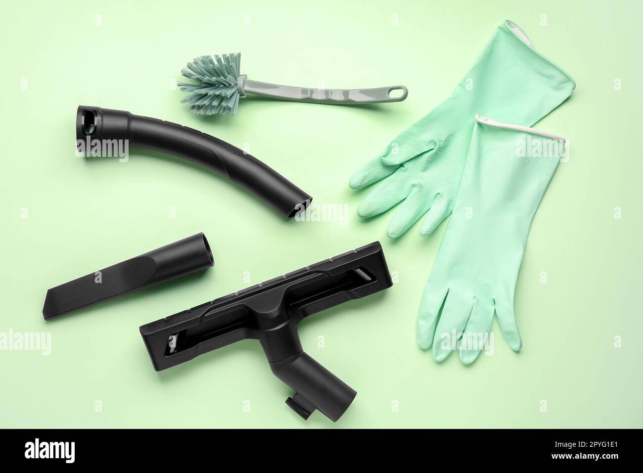 Accessori per aspirapolvere con spazzola e guanti su sfondo verde Foto  stock - Alamy