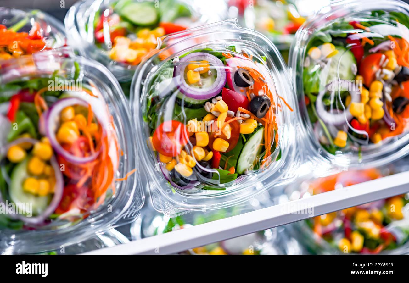 Scatole con insalate di verdure preconfezionate in un frigorifero commerciale Foto Stock