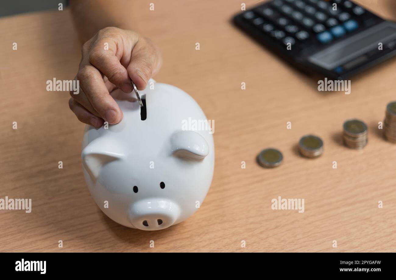 donna che mette la moneta in piggy bank e risparmiare denaro per il futuro piano e fondo pensionistico guadagnare denaro o investimento o tassa per il concetto di business. Foto Stock