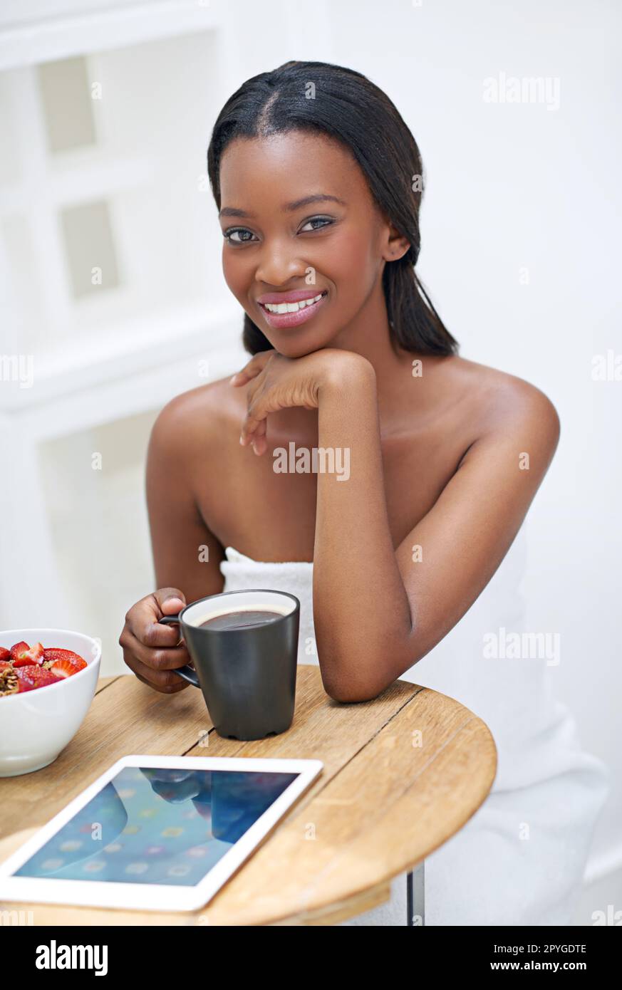 Tutto ciò di cui ho bisogno per iniziare bene la giornata. Una giovane donna che mangia fragole. Foto Stock