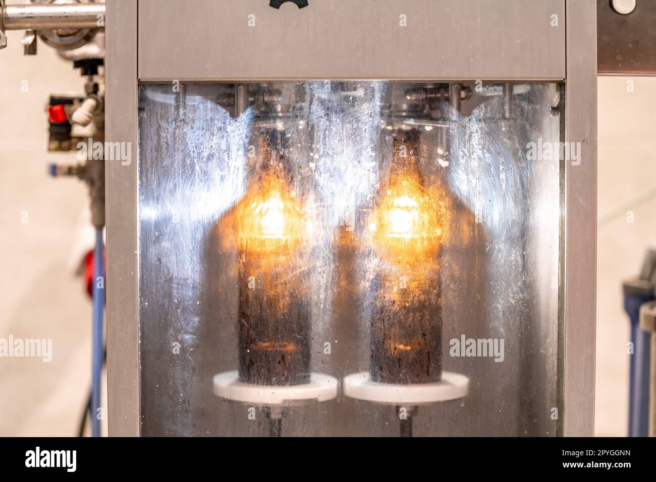 macchina per il lavaggio e il riempimento di bottiglie di vetro con birra Foto Stock